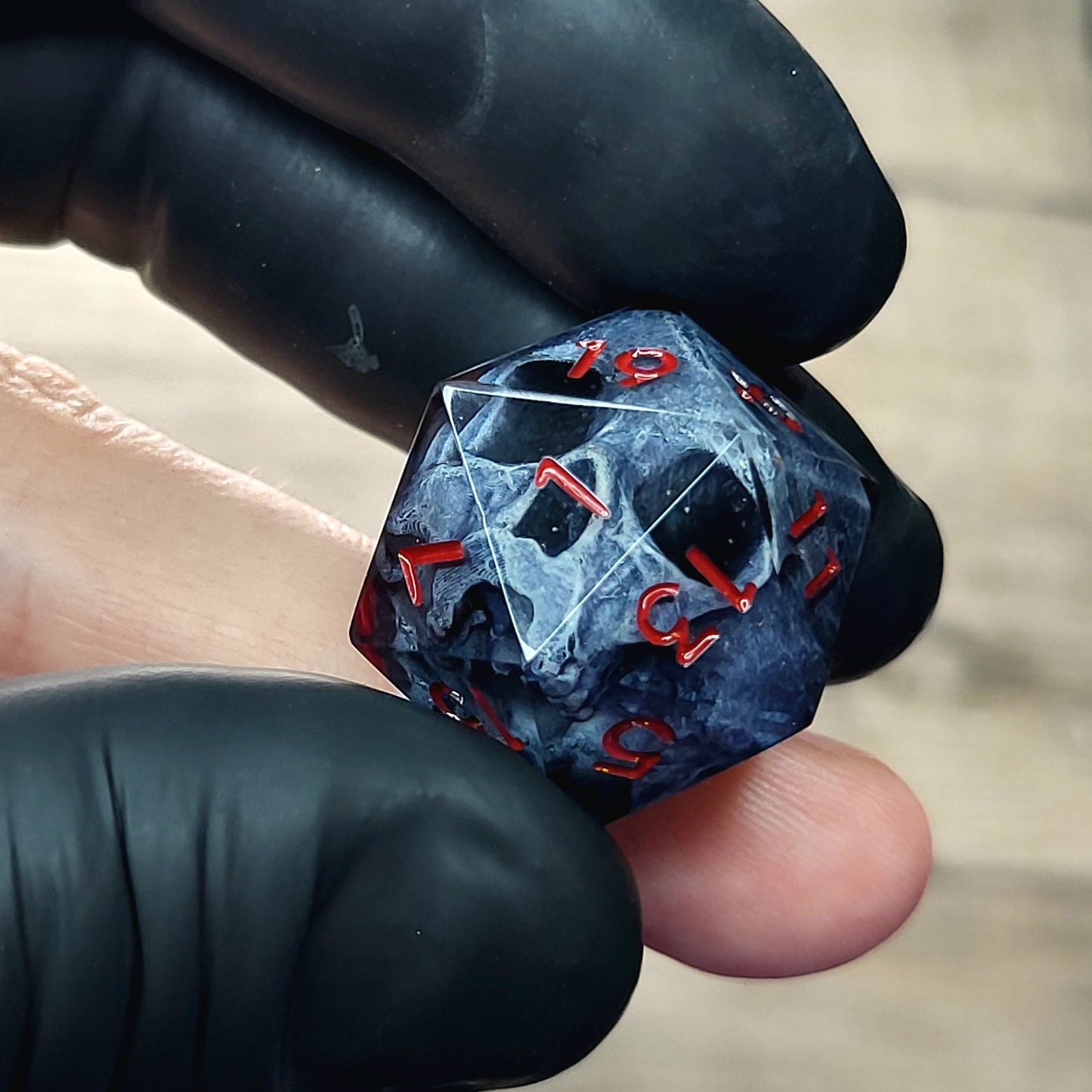 This is a single set of one D20 DnD die with a dark grey skull inside ,black resin and red numbers