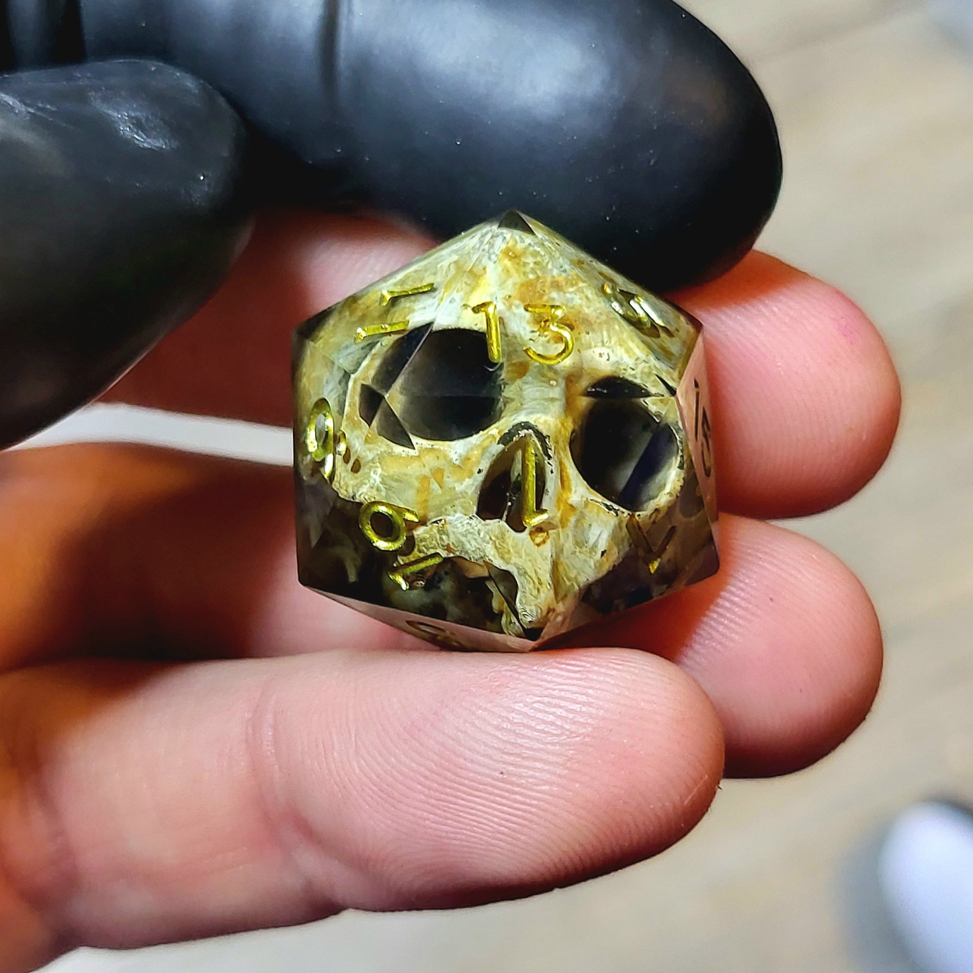This is a single set of one D20 DND die with a light brown skull inside ,black resin and green gold numbers