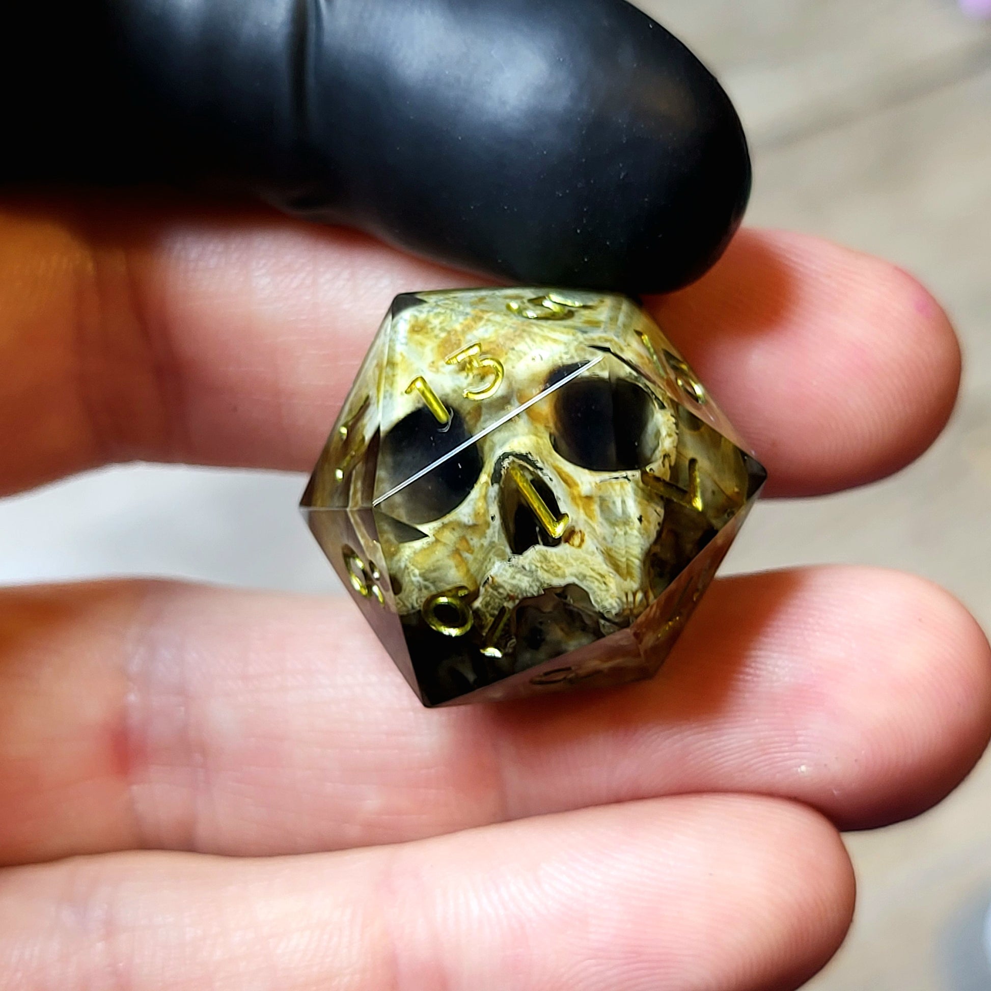 This is a single set of one D20 DND die with a light brown skull inside ,black resin and green gold numbers