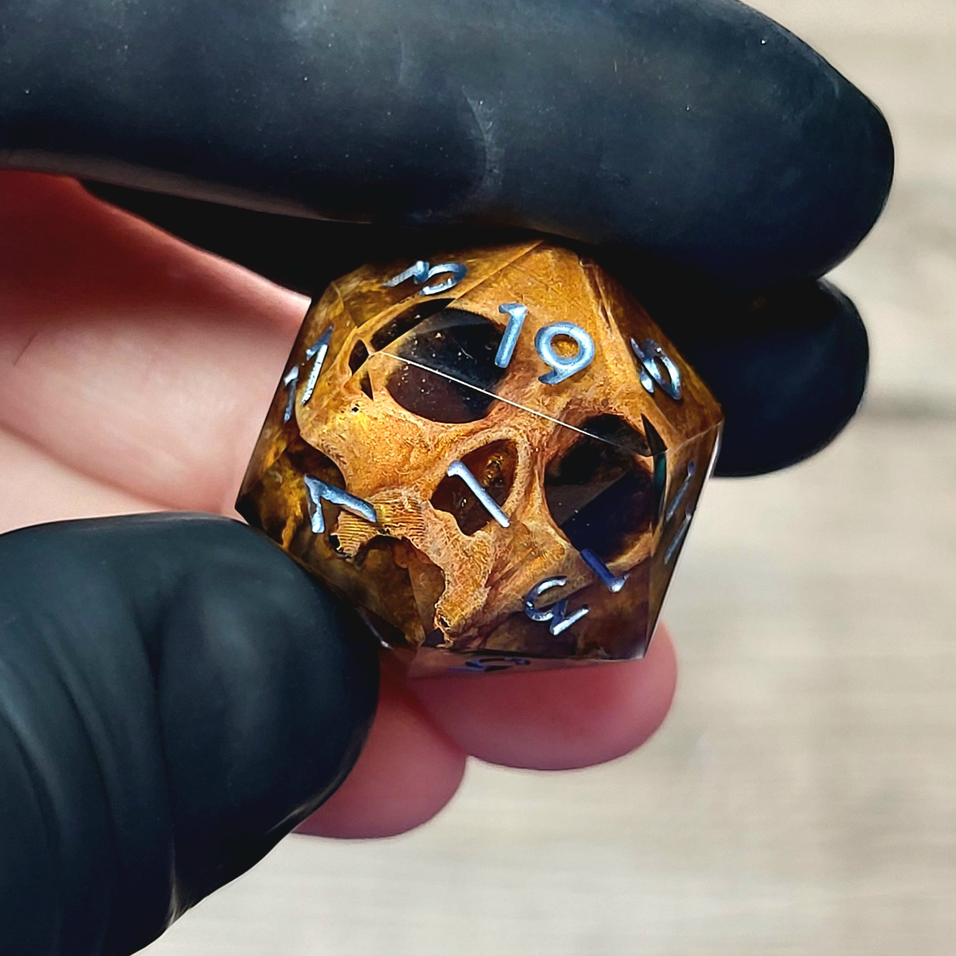 This is a single set of one D20 DnD die with a light brown skull inside , black resin and silver numbers