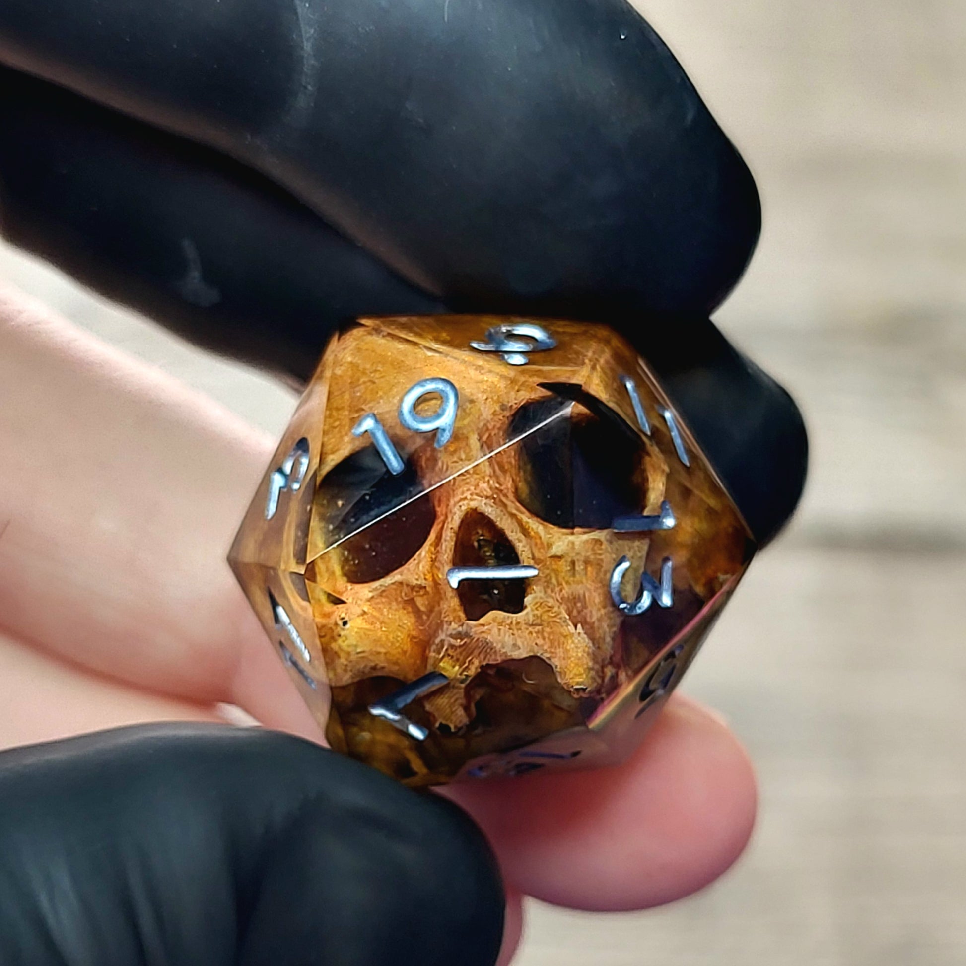 This is a single set of one D20 DnD die with a light brown skull inside , black resin and silver numbers