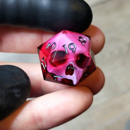 This is a single set of one D20 DND die with a pink skull inside ,red resin and black silver numbers
