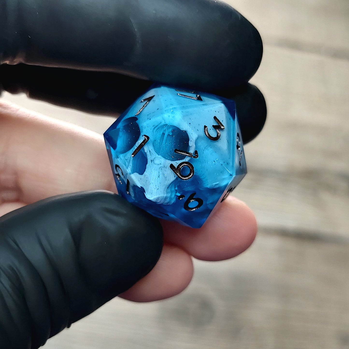 This is a single set of one D20 DnD die with a white skull inside ,blue resin and metal dark numbers