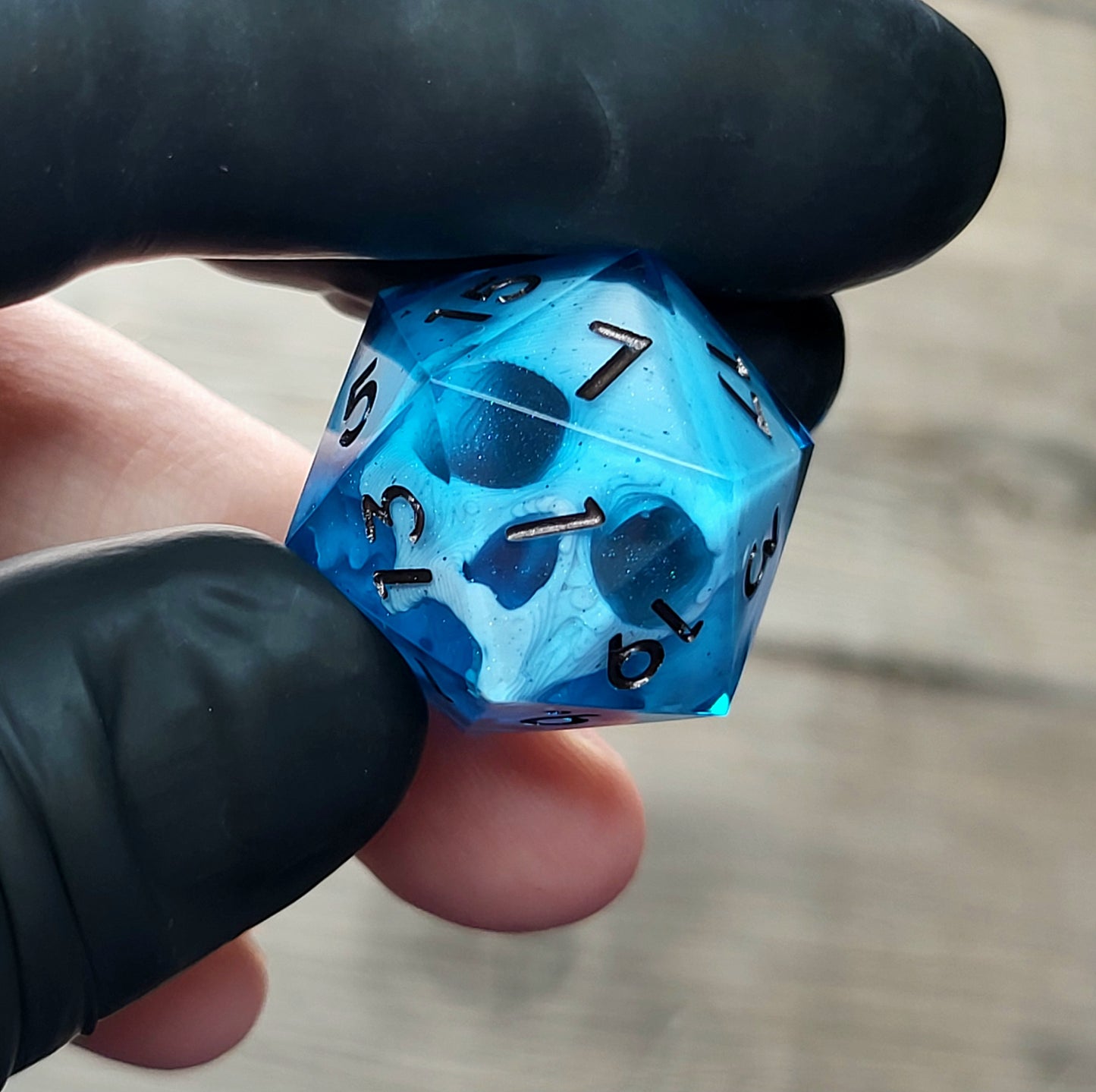 This is a single set of one D20 DnD die with a white skull inside ,blue resin and metal dark numbers