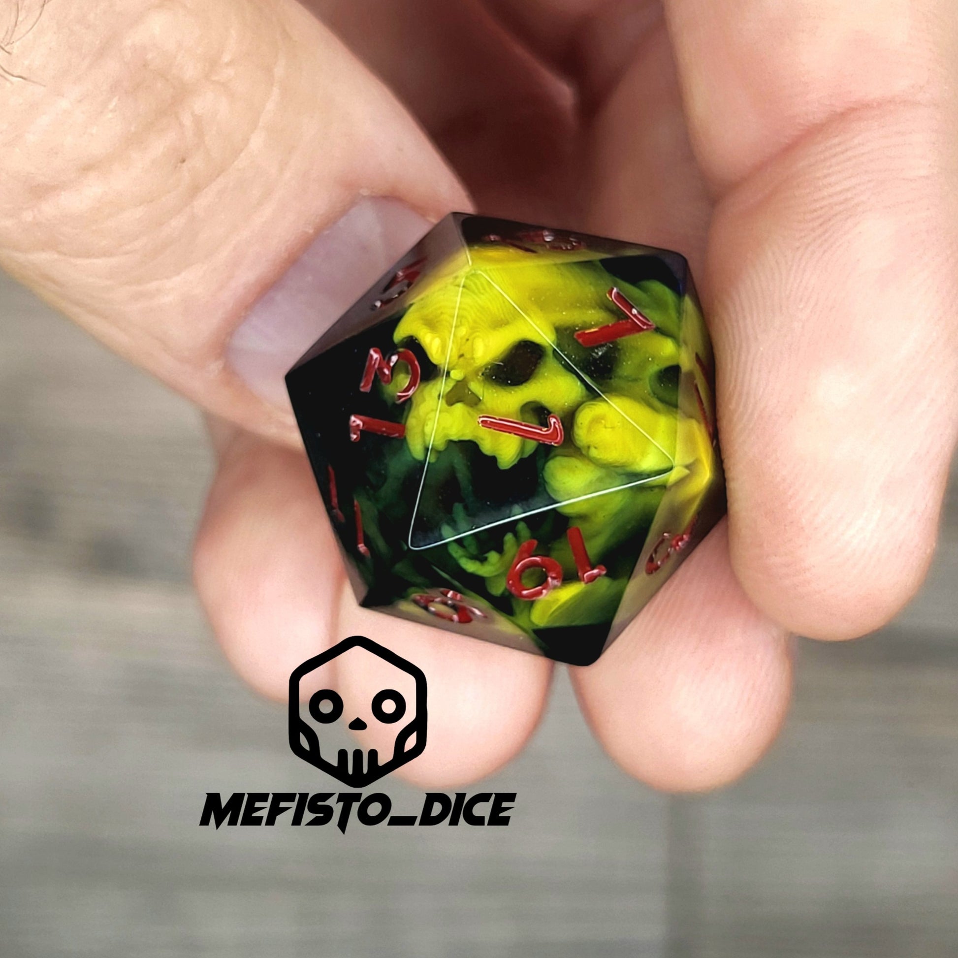 Black resin DnD dice with yellow skull inside and red engraved numbers