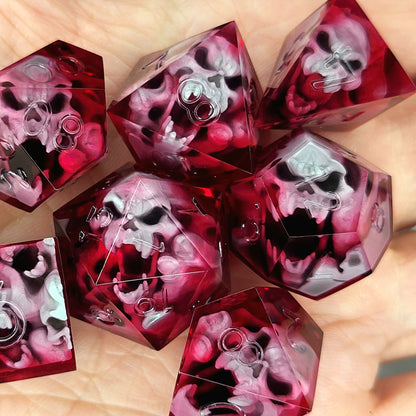 Handmade sharp edge resin dice set with floating skull inclusions in transparent crimson red resin