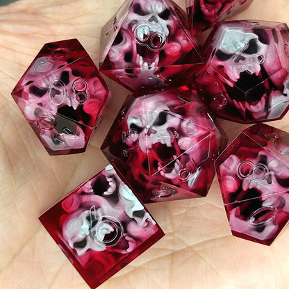 Handmade sharp edge resin dice set with floating skull inclusions in transparent crimson red resin