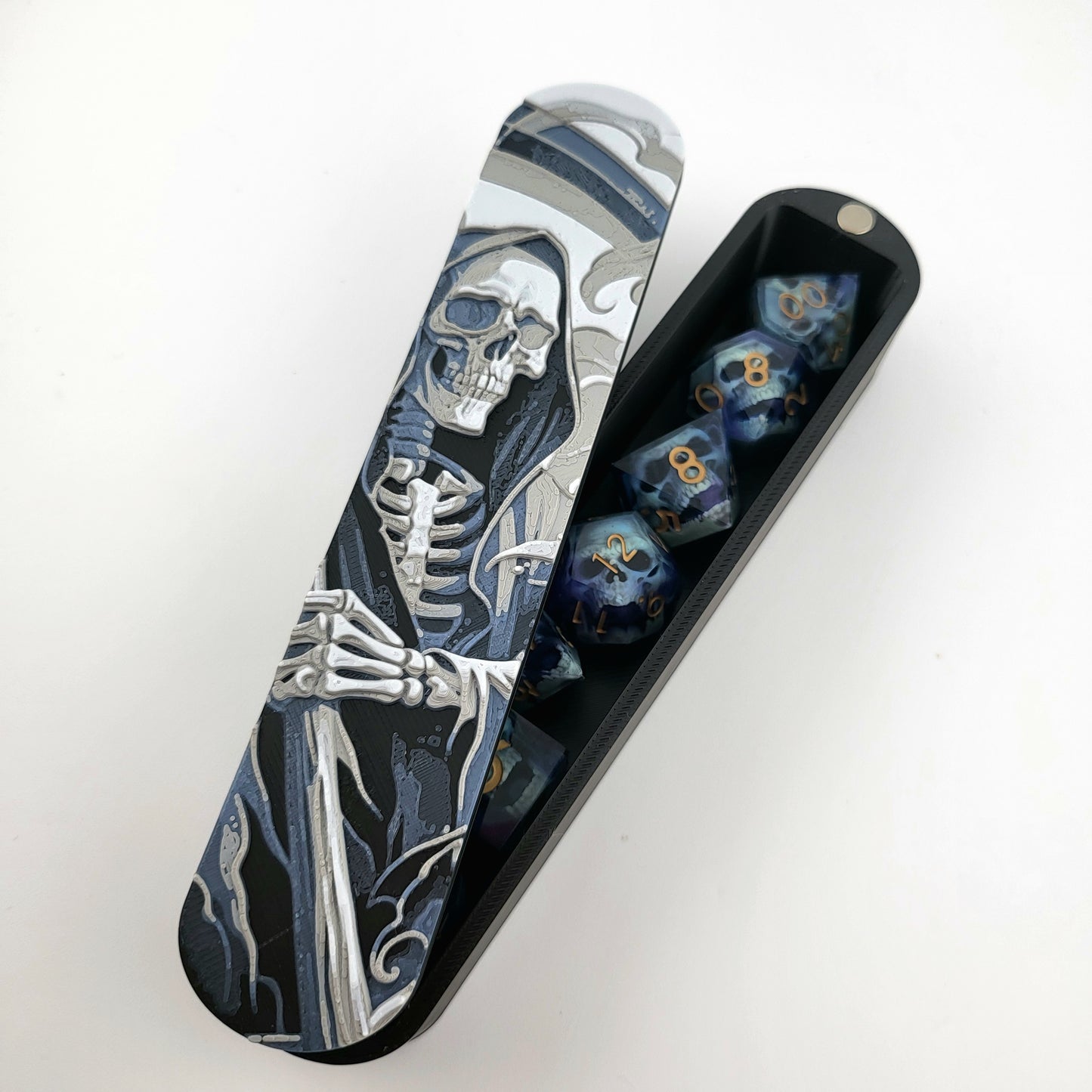 Close-up of a dice box featuring a detailed skeleton reaper illustration in shades of grey and blue, designed for storing RPG dice, handcrafted by Mefisto_Dice.