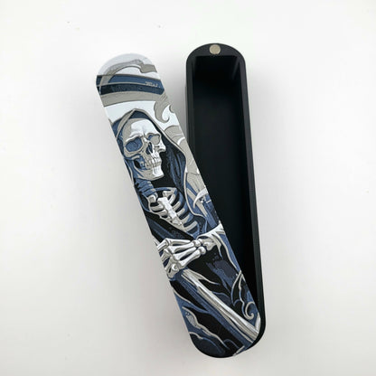 Close-up of a dice box featuring a detailed skeleton reaper illustration in shades of grey and blue, designed for storing RPG dice, handcrafted by Mefisto_Dice.