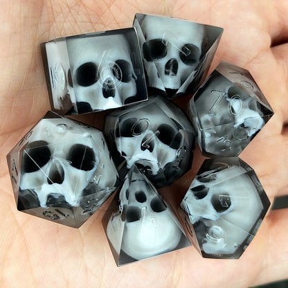 Handmade polyhedral dice set for Dungeons & Dragons (D&D) and tabletop RPGs, crafted in black resin with white skulls embedded inside