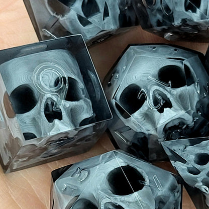 Black translucent polyhedral resin dice set with embedded red skulls inside, perfect for D&D (Dungeons & Dragons) and dark fantasy tabletop RPG campaigns