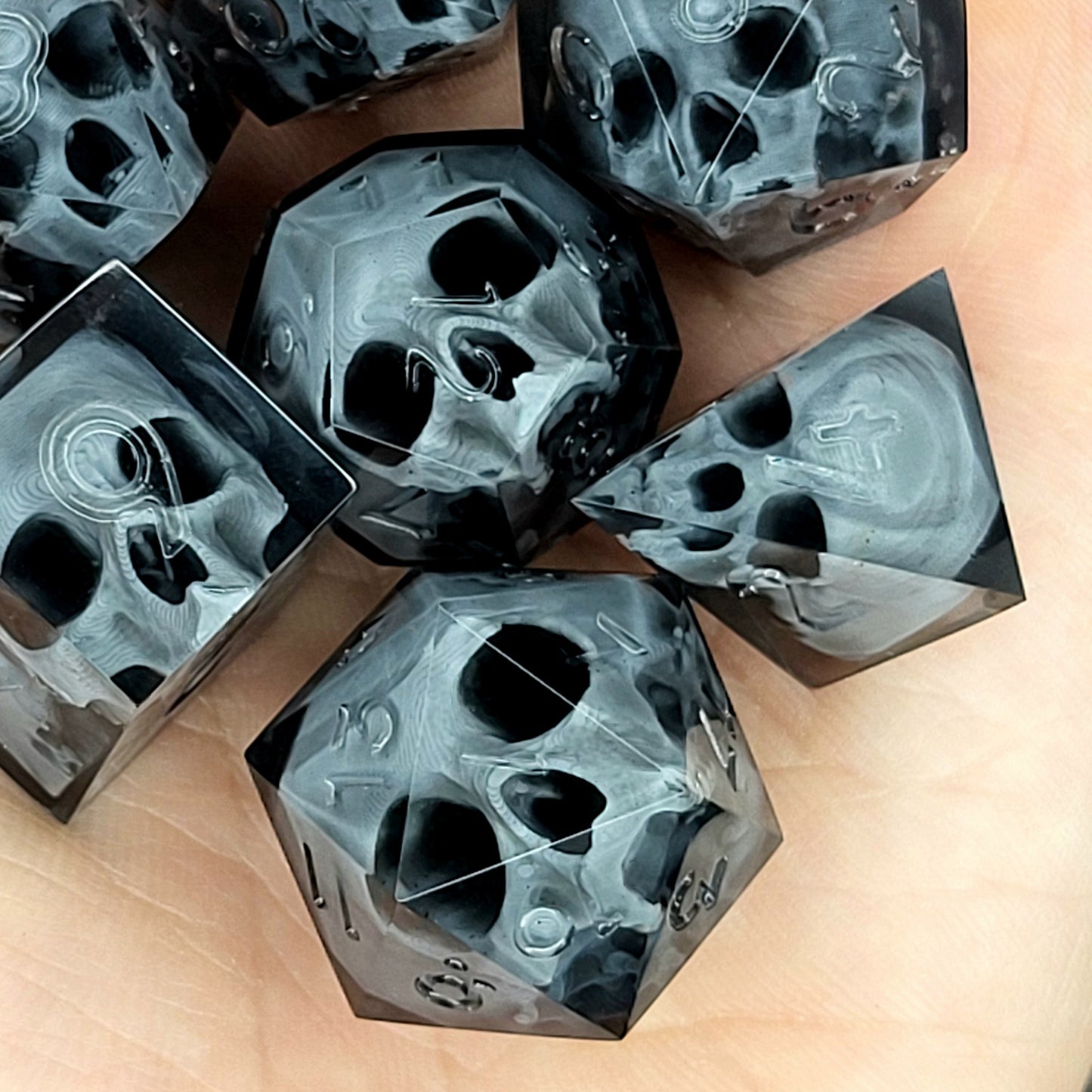 Black translucent polyhedral resin dice set with embedded red skulls inside, perfect for D&D (Dungeons & Dragons) and dark fantasy tabletop RPG campaigns