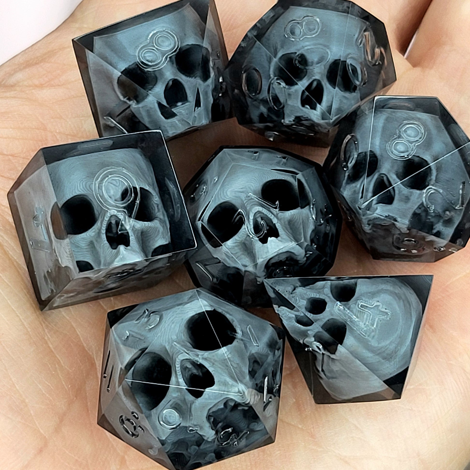Black translucent polyhedral resin dice set with embedded red skulls inside, perfect for D&D (Dungeons & Dragons) and dark fantasy tabletop RPG campaigns
