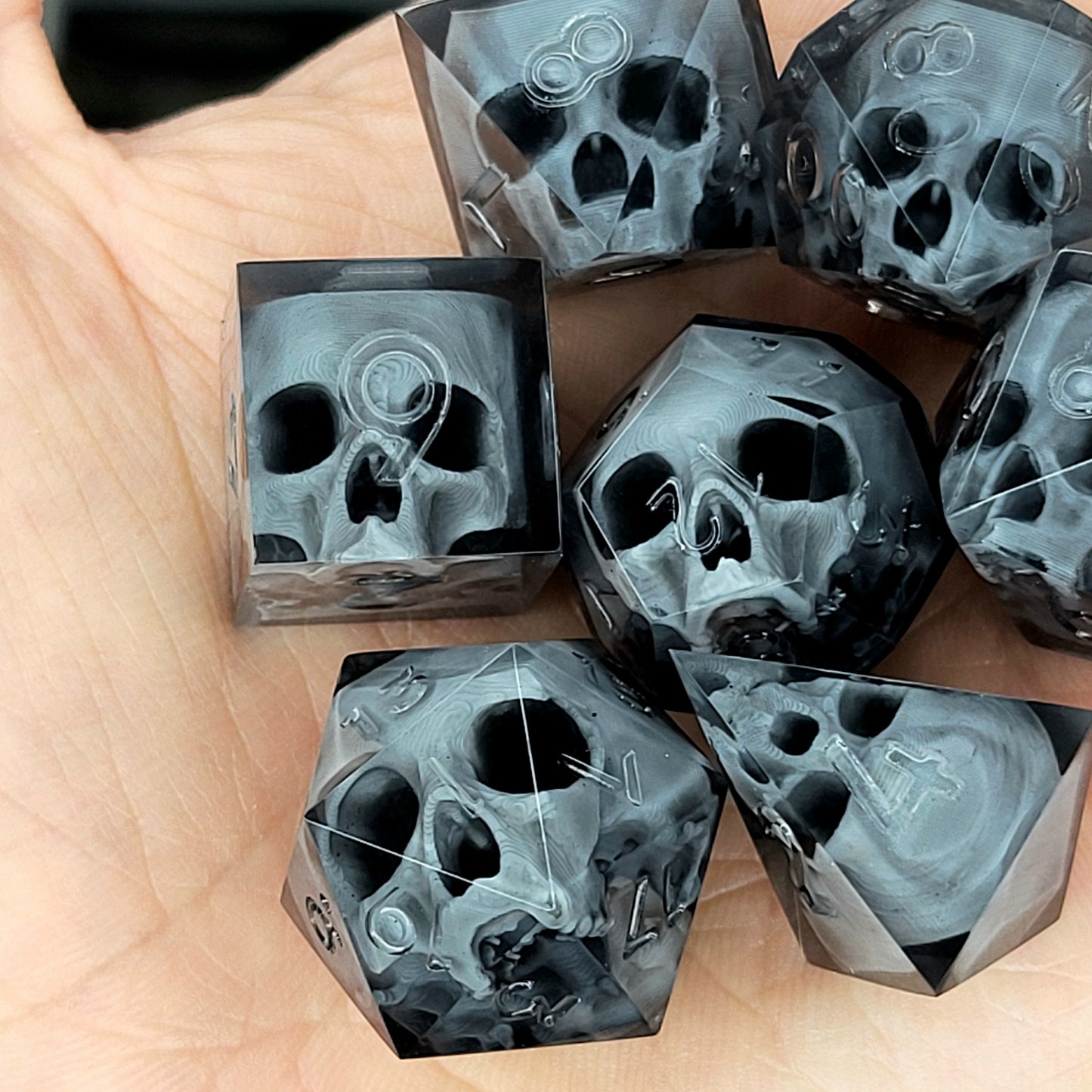 Black translucent polyhedral resin dice set with embedded red skulls inside, perfect for D&D (Dungeons & Dragons) and dark fantasy tabletop RPG campaigns
