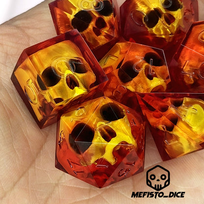 Handmade translucent red resin dice set with embedded skull designs resting in a hand. Gothic RPG polyhedral dice for Dungeons & Dragons and tabletop gaming with dark fantasy aesthetic