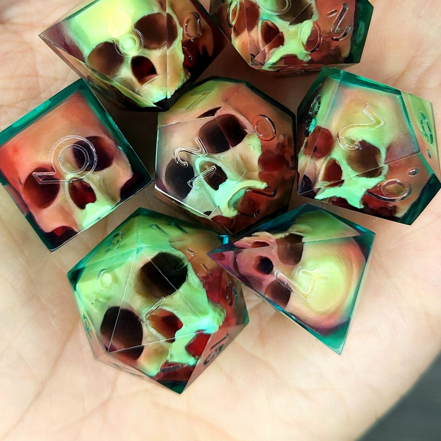 Handmade sharp edge resin dice set with floating skull design in transparent green and red resin