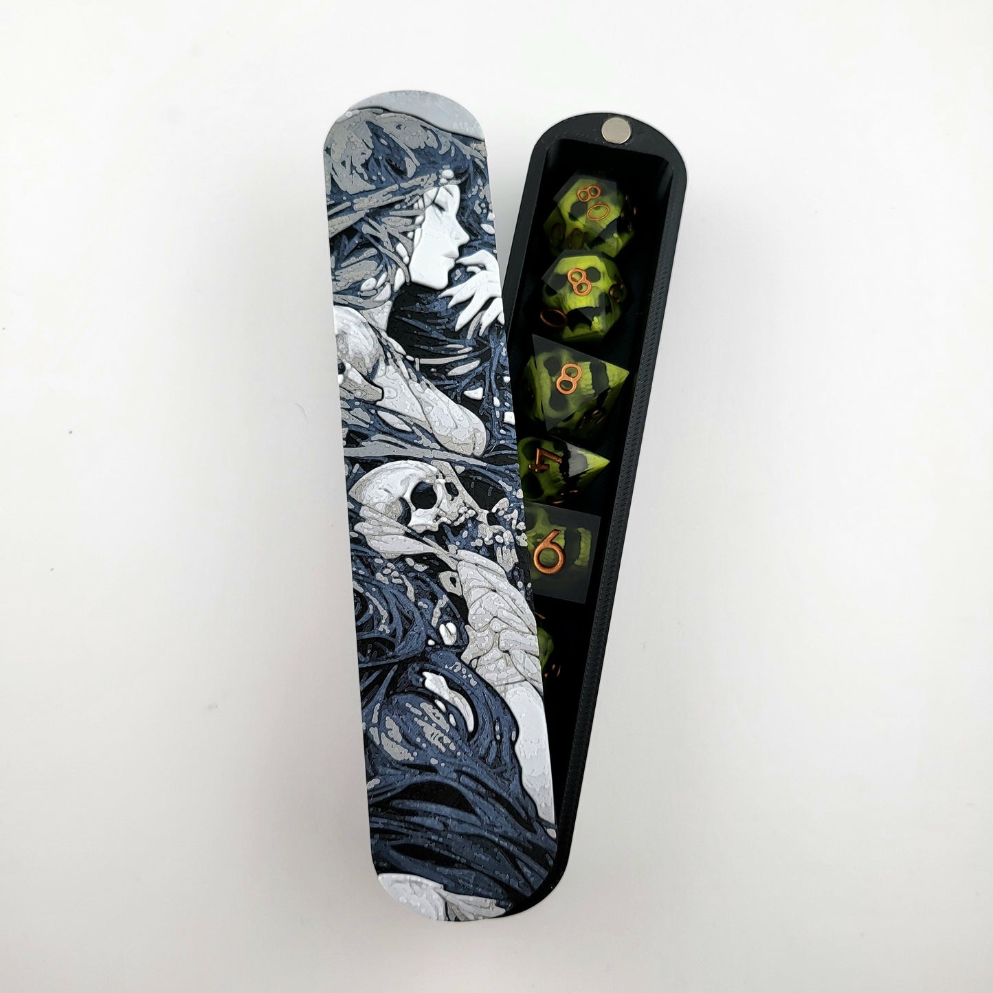 Close-up of a dice box featuring a detailed dark fantasy illustration of a woman surrounded by swirling shadows and skull motifs, shown partially open with RPG dice stored inside, designed by Mefisto_Dice.