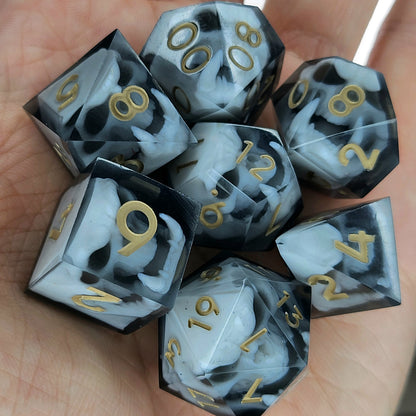 Black and white resin dice set featuring detailed orc skulls with gold numbers, fantasy RPG dice for DnD and tabletop roleplaying games