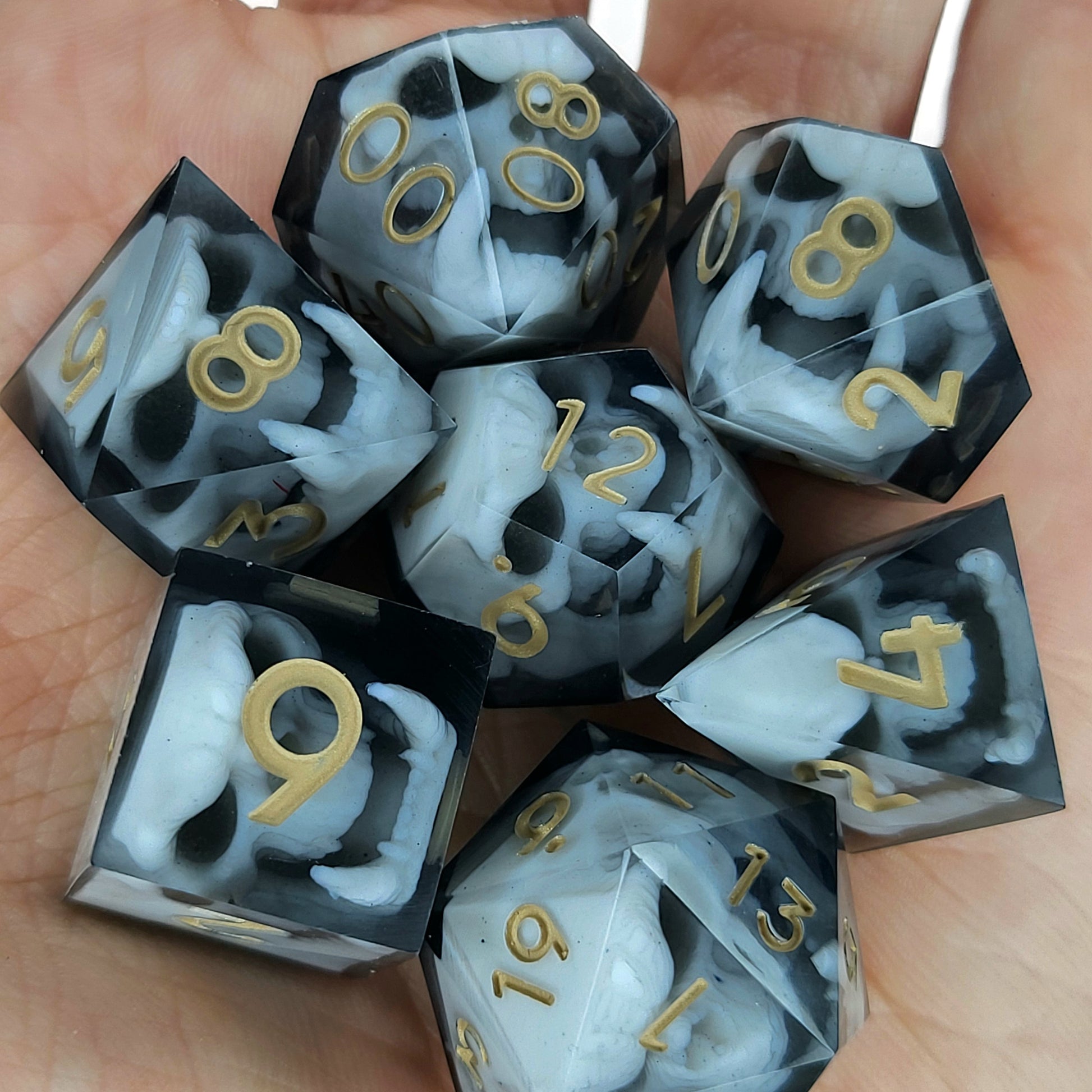 Black and white resin dice set featuring detailed orc skulls with gold numbers, fantasy RPG dice for DnD and tabletop roleplaying games