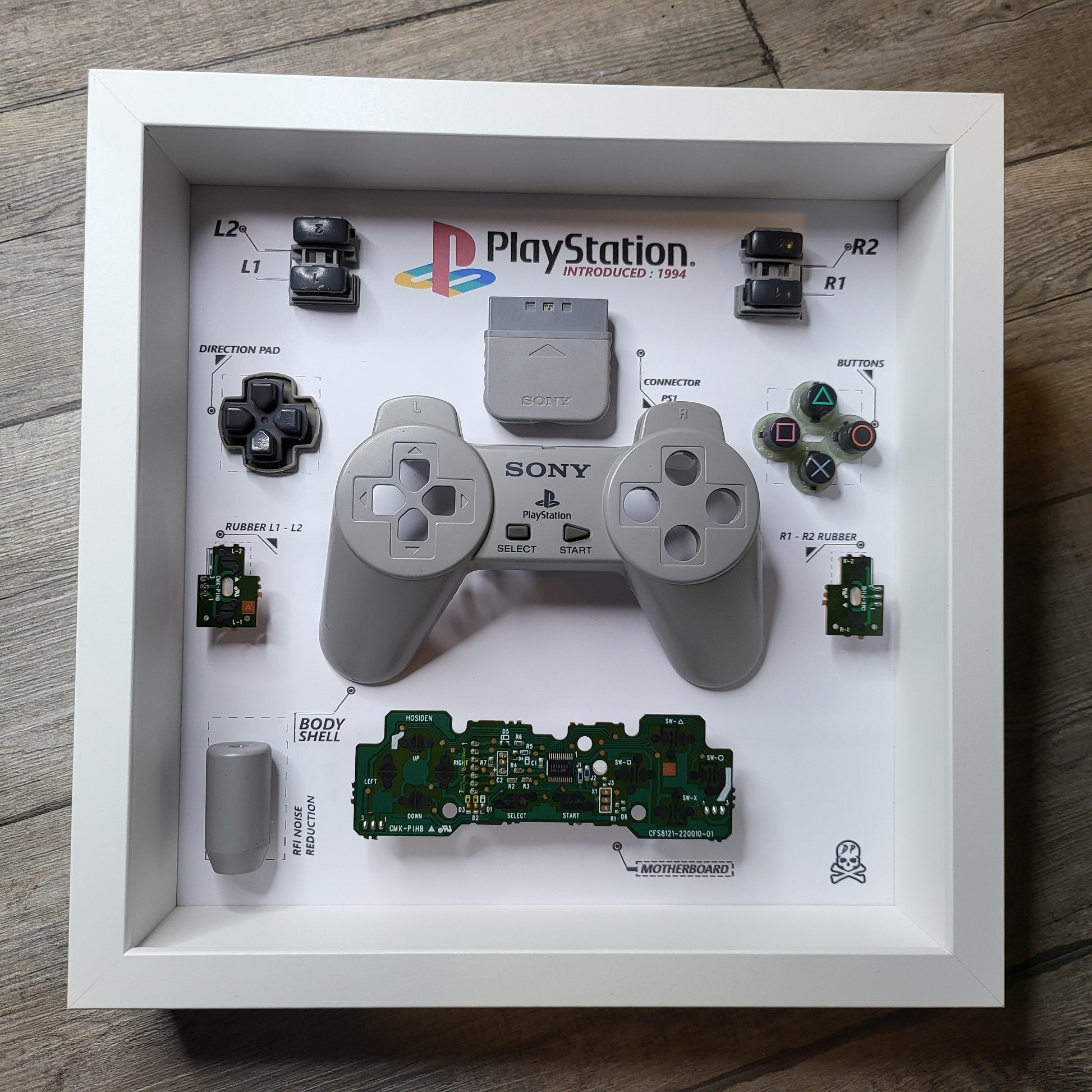 Shadow Box 10x10 with wood frame and polycarbonate glass for wall and Tabletop containing a disassembled controller for Playstation and Nintendo