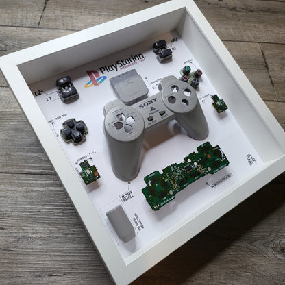 Shadow Box 10x10 with wood frame and polycarbonate glass for wall and Tabletop containing a disassembled controller for Playstation and Nintendo