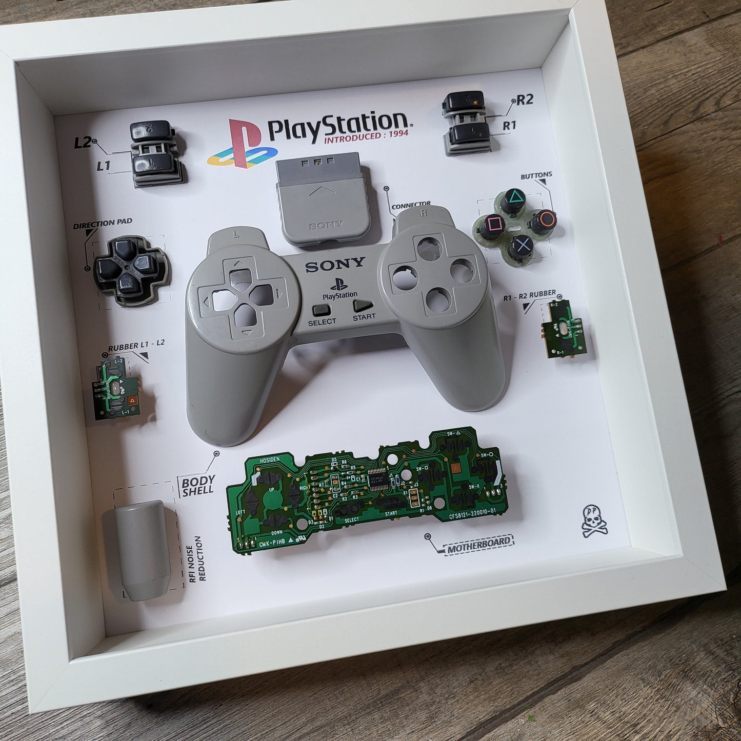 Shadow Box 10x10 with wood frame and polycarbonate glass for wall and Tabletop containing a disassembled controller for Playstation and Nintendo