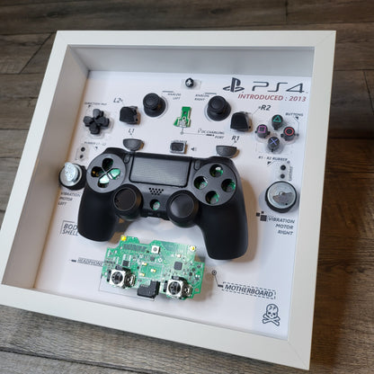 Shadow Box 10x10 with wood frame and polycarbonate glass for wall and Tabletop containing a disassembled controller for Playstation and Nintendo