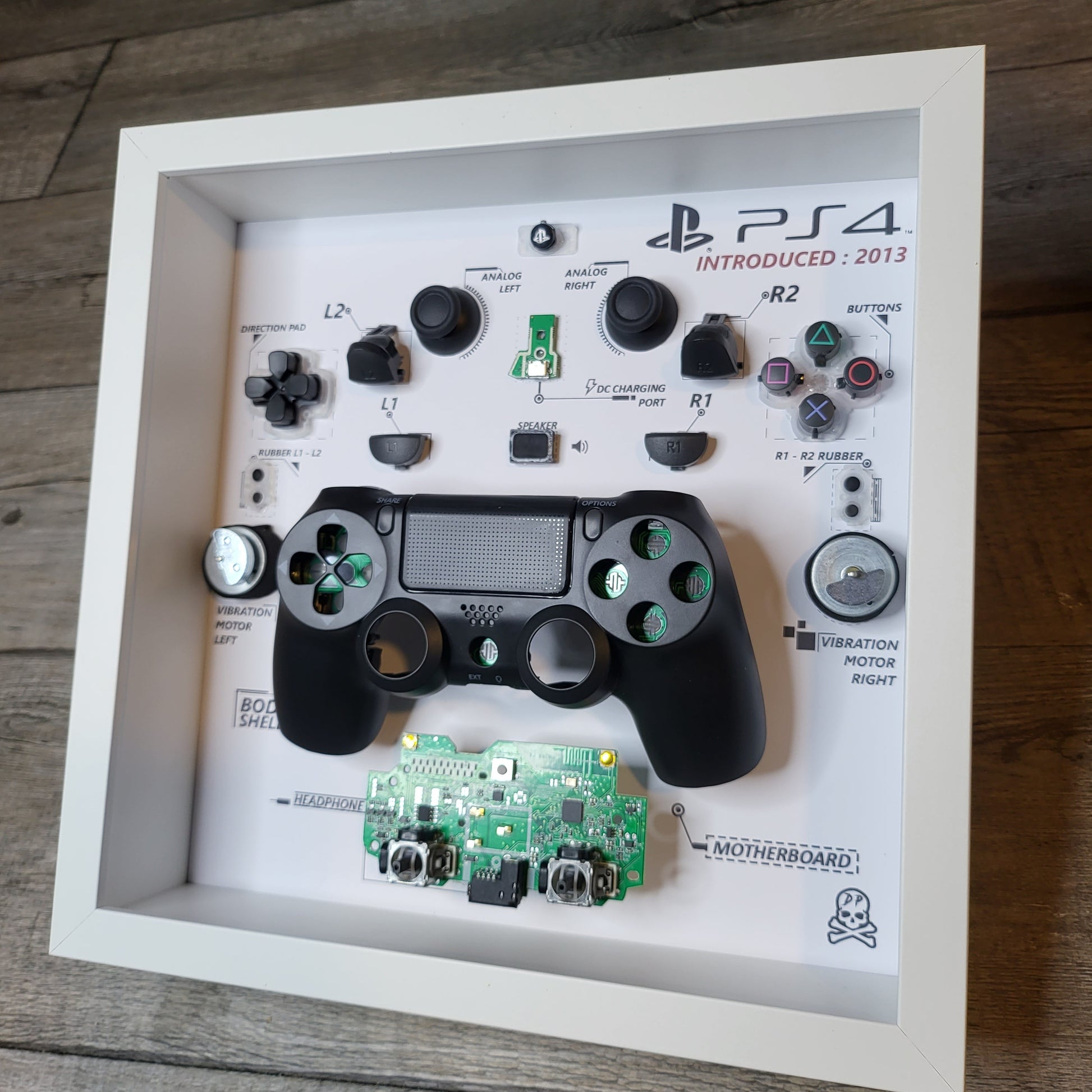 Shadow Box 10x10 with wood frame and polycarbonate glass for wall and Tabletop containing a disassembled controller for Playstation and Nintendo