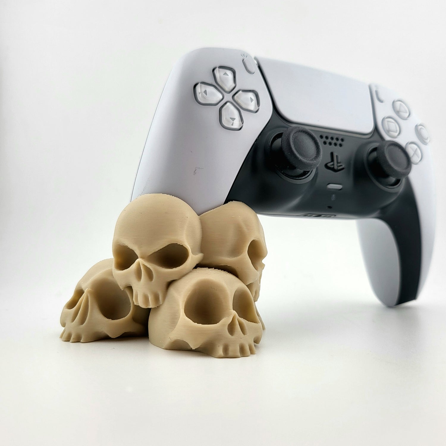 A stand for Ps5 controller featuring a design with a tower of 4 tiny skulls, 3D printed with high-quality PLA.