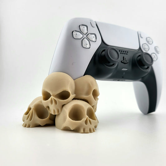 A stand for Ps5 controller featuring a design with a tower of 4 tiny skulls, 3D printed with high-quality PLA.