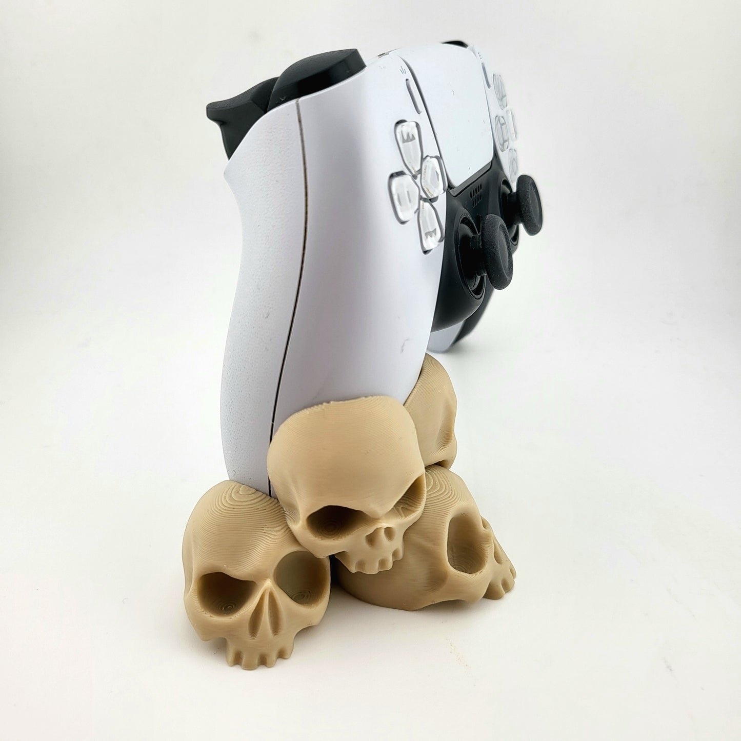 One stand for Ps5 controller featuring a design with a tower of 4 tiny skulls, 3D printed with high-quality PLA.