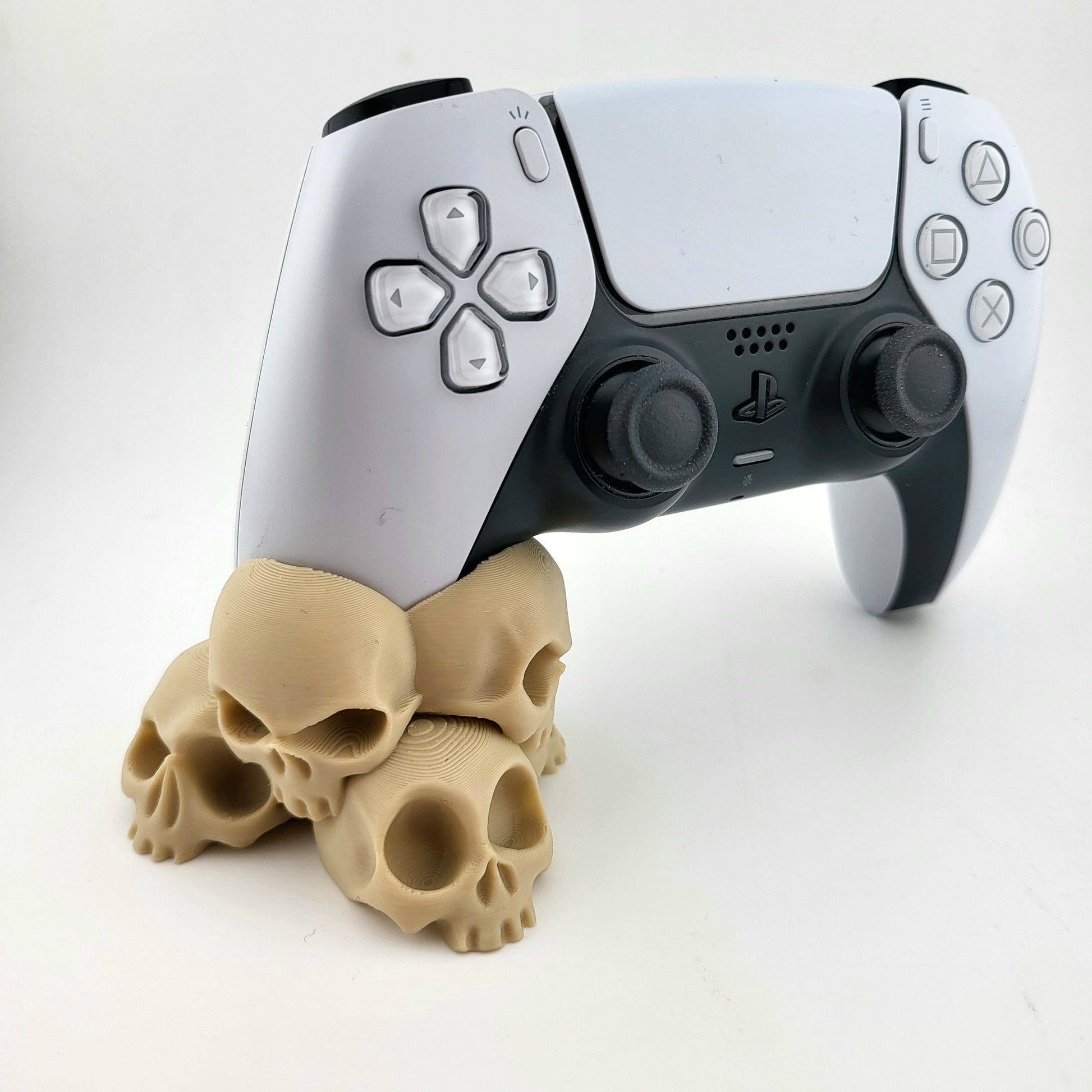 A stand for Ps5 controller featuring a design with a tower of 4 tiny skulls, 3D printed with high-quality PLA.