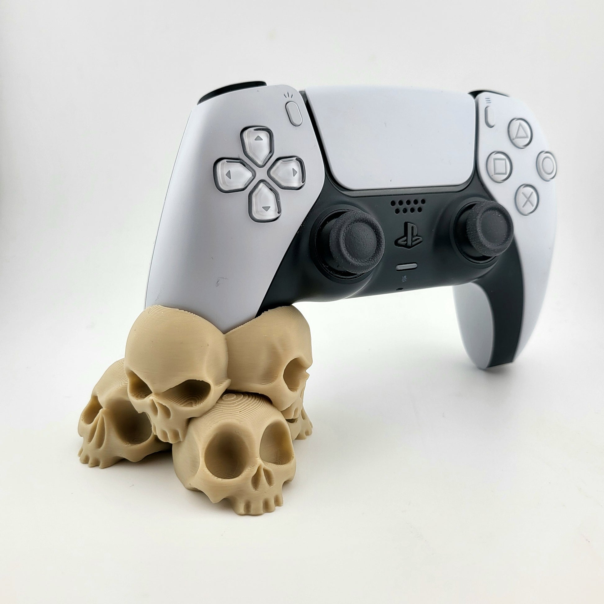 A stand for Ps5 controller featuring a design with a tower of 4 tiny skulls, 3D printed with high-quality PLA.