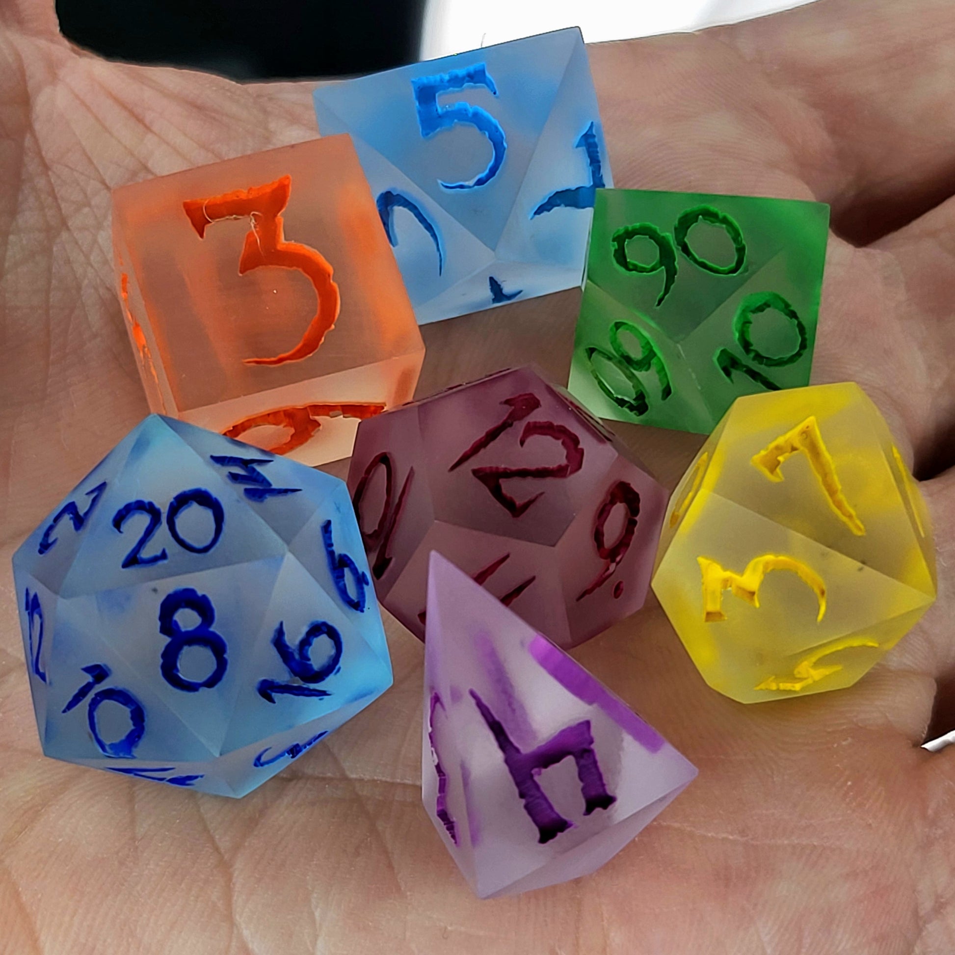 Multicolor frosted resin DnD dice set with matte finish in blue, green, yellow, orange, purple, and red tones