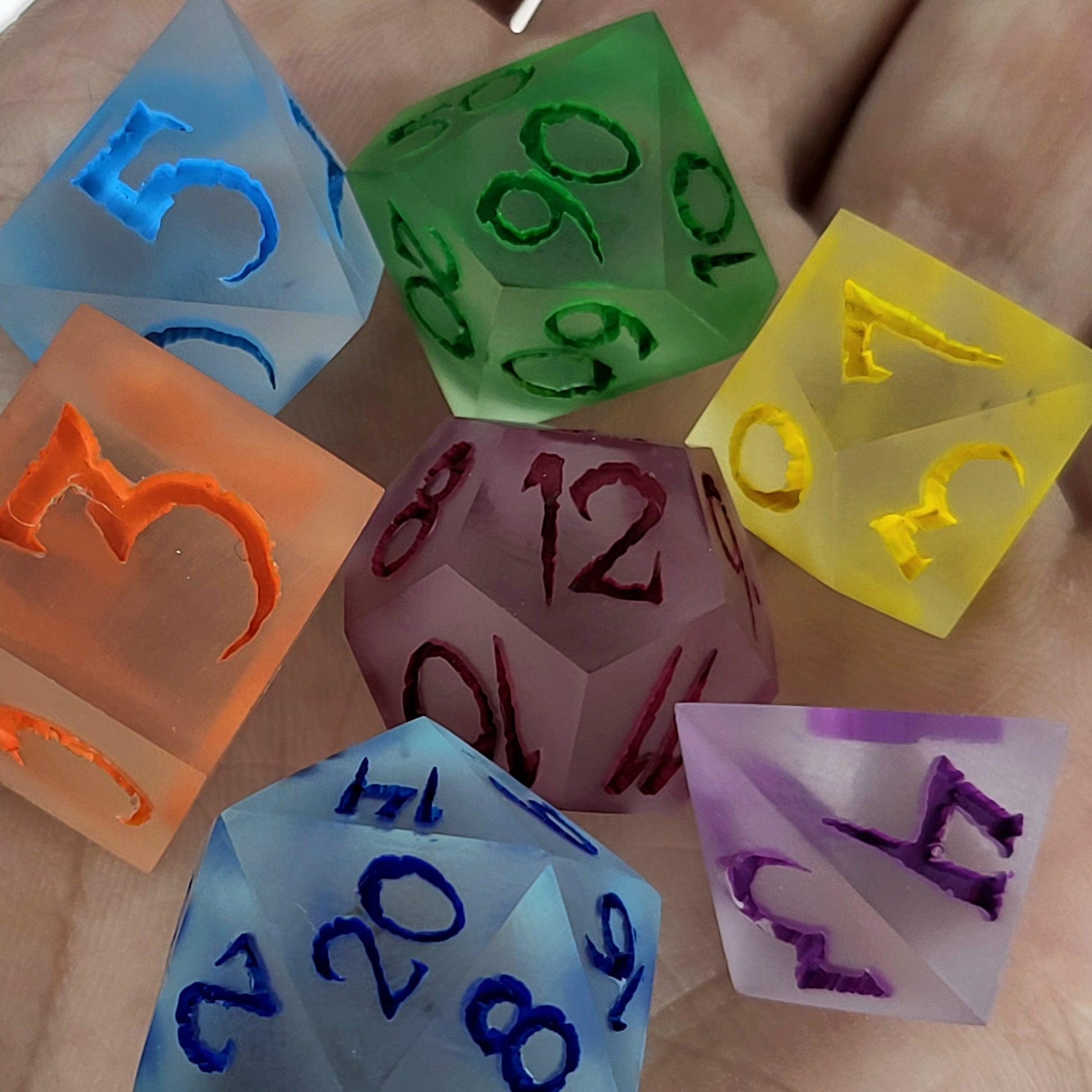 Multicolor frosted resin DnD dice set with matte finish in blue, green, yellow, orange, purple, and red tones