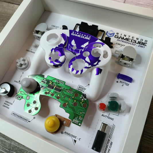 Shadow Box 10x10 with wood frame and polycarbonate glass for wall and Tabletop containing a disassembled controller for Playstation and Nintendo