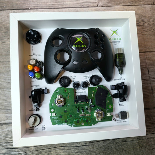 Shadow Box 10x10 with wood frame and polycarbonate glass for wall and Tabletop containing a disassembled controller for Playstation and Nintendo