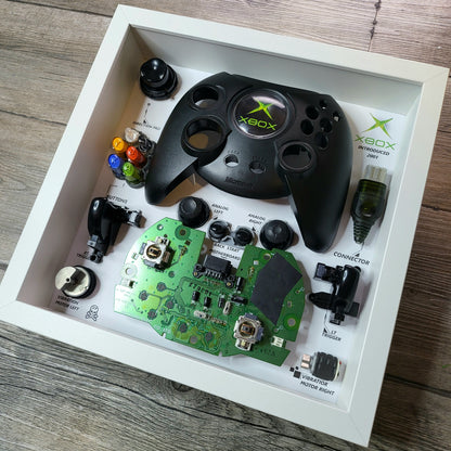 Shadow Box 10x10 with wood frame and polycarbonate glass for wall and Tabletop containing a disassembled controller for Playstation and Nintendo