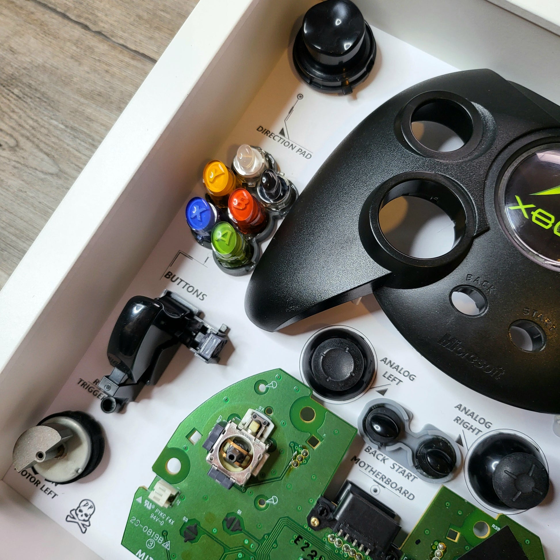 Shadow Box 10x10 with wood frame and polycarbonate glass for wall and Tabletop containing a disassembled controller for Playstation and Nintendo