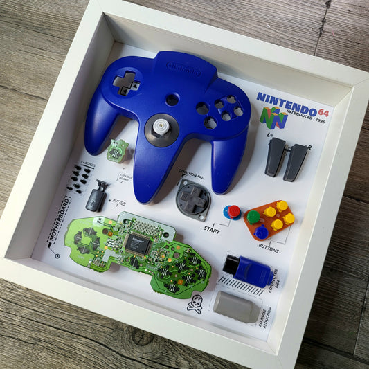 Shadow Box 10x10 with wood frame and polycarbonate glass for wall and Tabletop containing a disassembled controller for Playstation and Nintendo