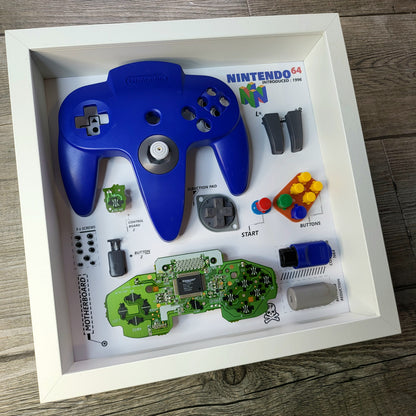 Shadow Box 10x10 with wood frame and polycarbonate glass for wall and Tabletop containing a disassembled controller for Playstation and Nintendo