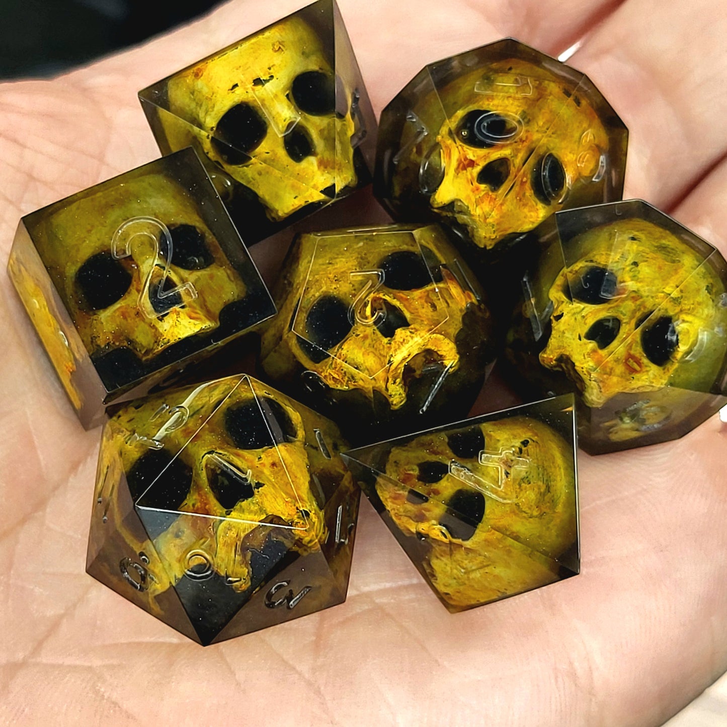 Black resin DnD dice set with detailed yellow skulls inside