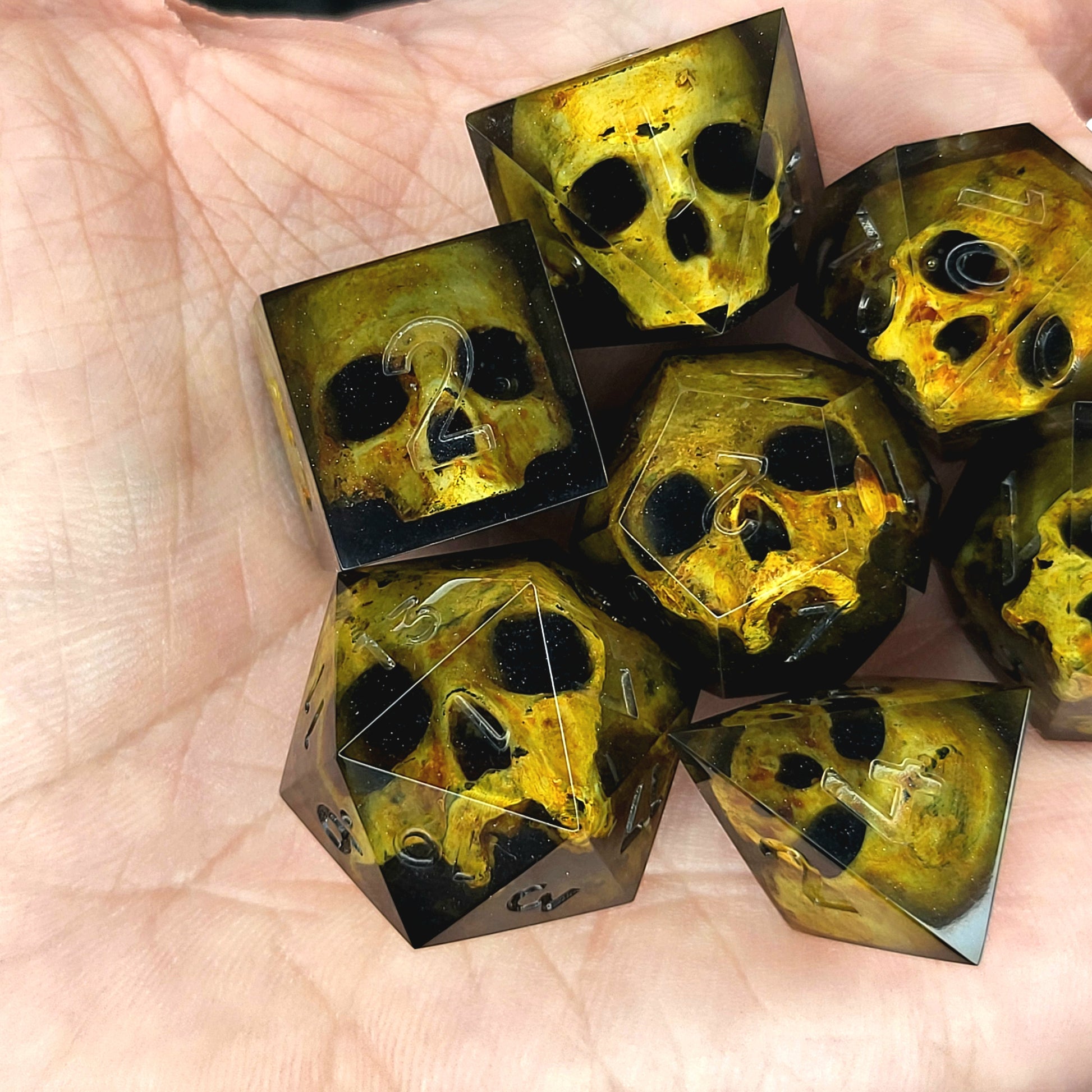 Black resin DnD dice set with detailed yellow skulls inside