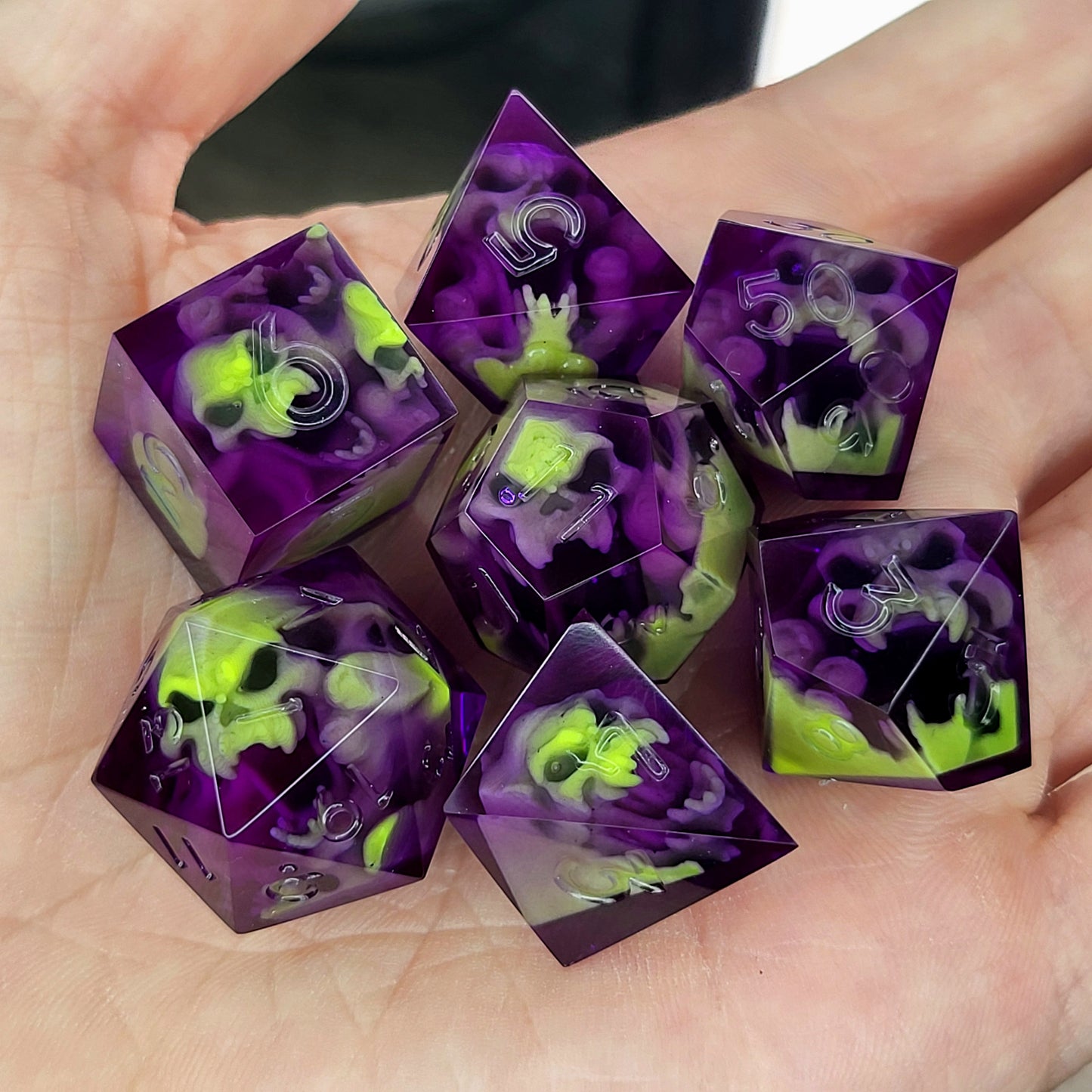 Purple resin DnD dice set with neon green skulls inside