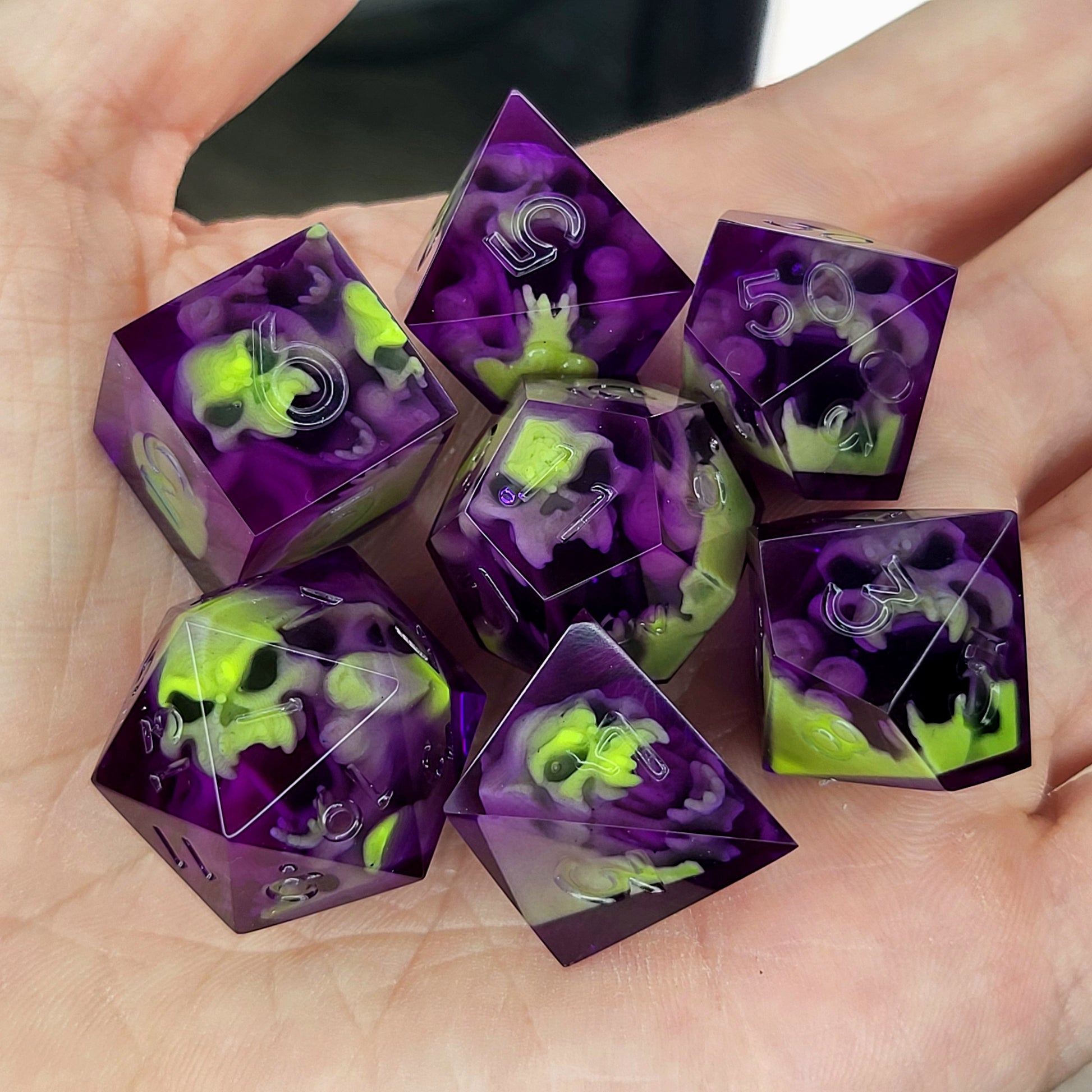 Purple resin DnD dice set with neon green skulls inside