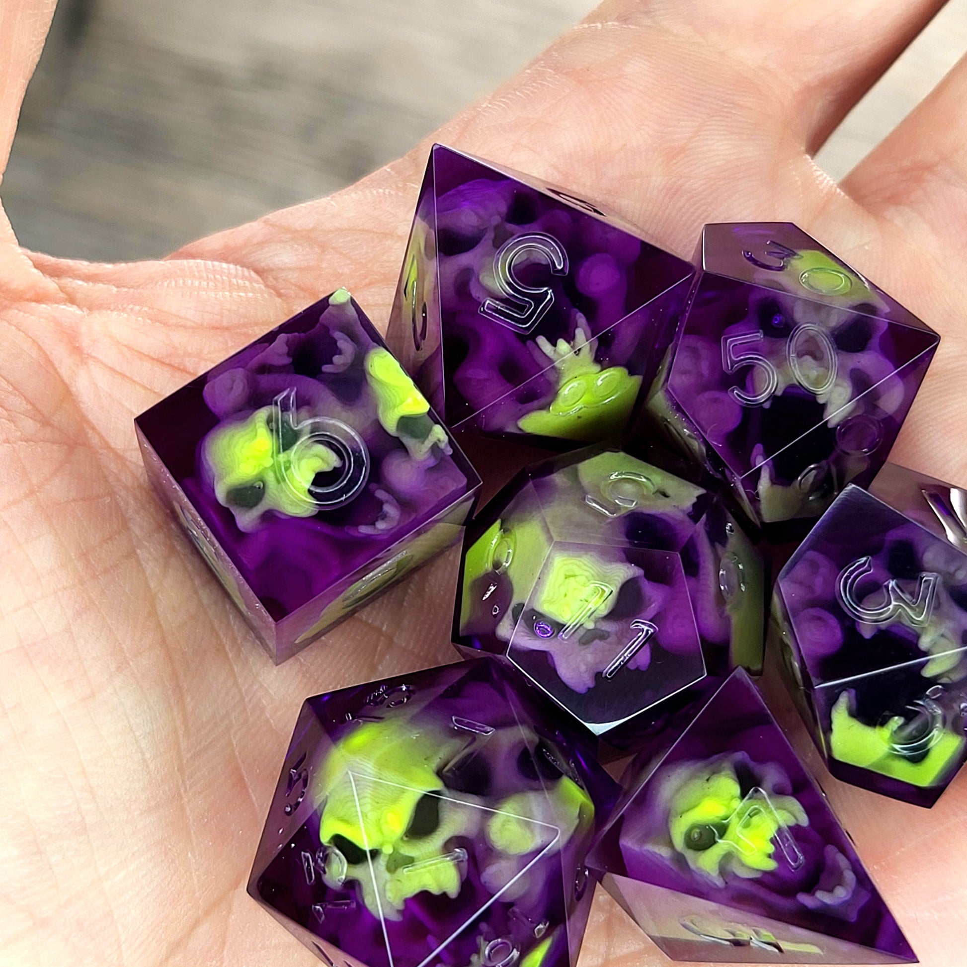 Purple resin DnD dice set with neon green skulls inside