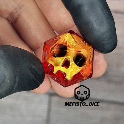 Red translucent resin D20 dice with a gold skull embedded inside, held between black-gloved fingers. Handmade gothic RPG dice for Dungeons & Dragons and dark fantasy tabletop gaming