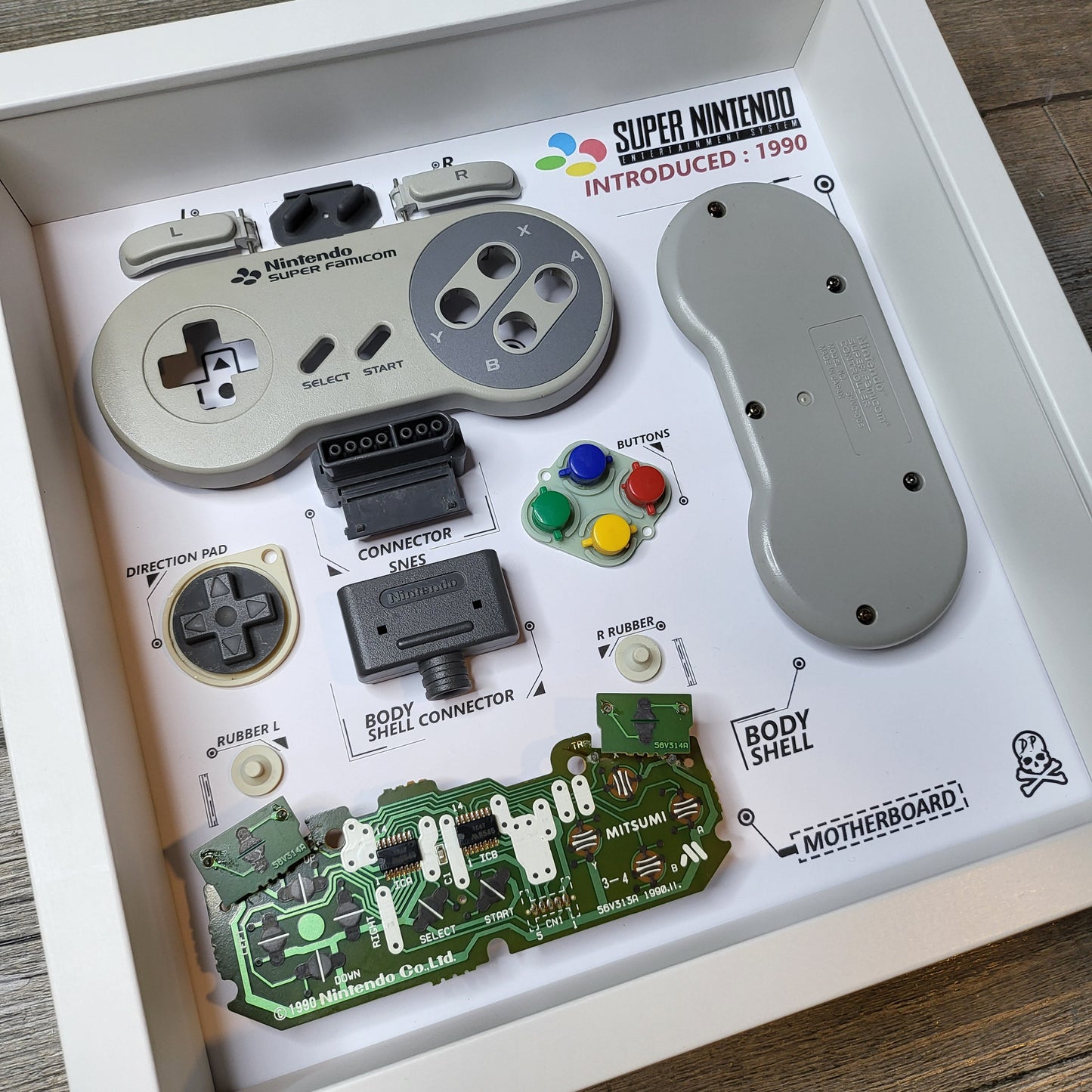 Shadow Box 10x10 with wood frame and polycarbonate glass for wall and Tabletop containing a disassembled controller for Playstation and Nintendo