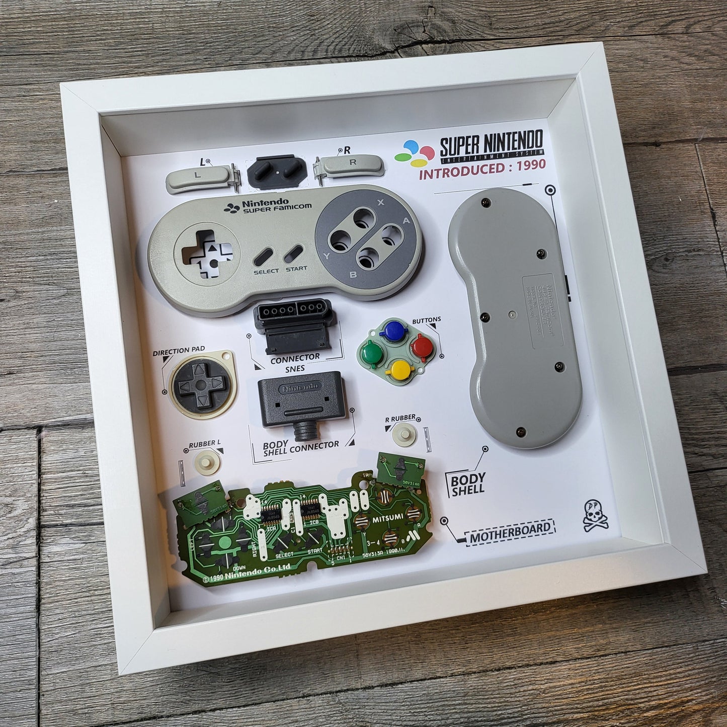 Shadow Box 10x10 with wood frame and polycarbonate glass for wall and Tabletop containing a disassembled controller for Playstation and Nintendo