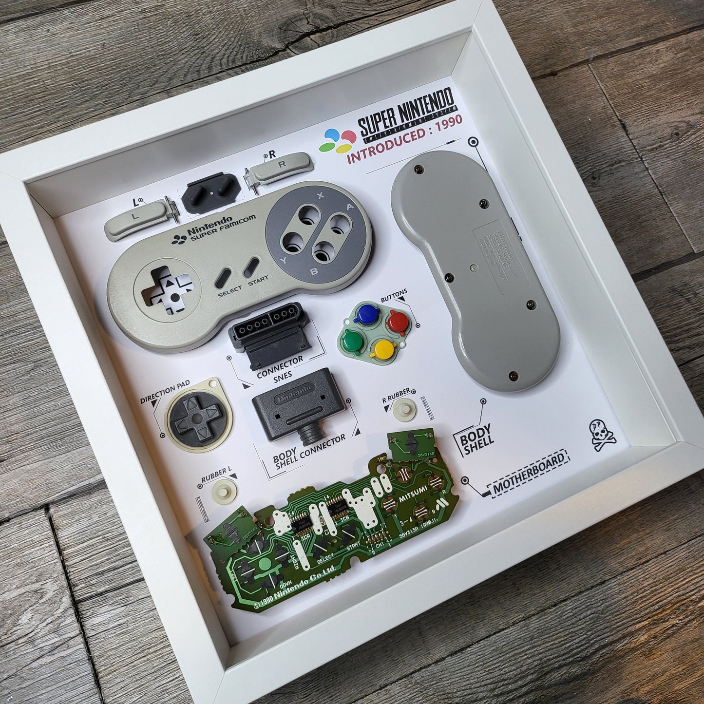 Shadow Box 10x10 with wood frame and polycarbonate glass for wall and Tabletop containing a disassembled controller for Playstation and Nintendo